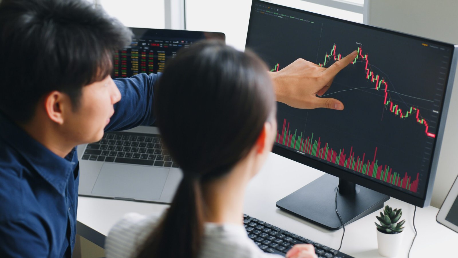 Asian man and woman looking at stocks