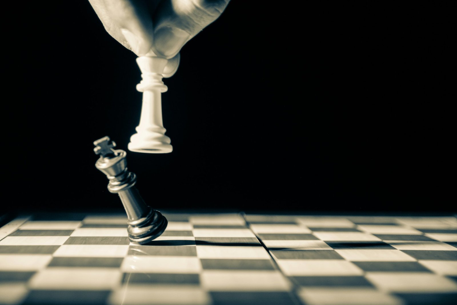 Chess players where one chess piece is falling showing strategy