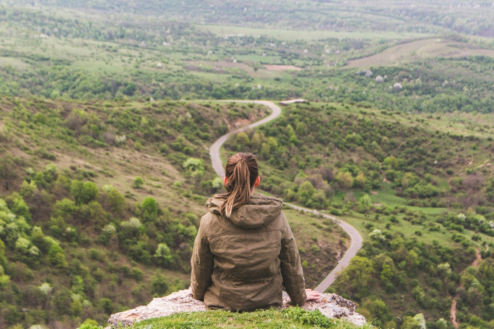 Woman looking at a winding road showing a journey
